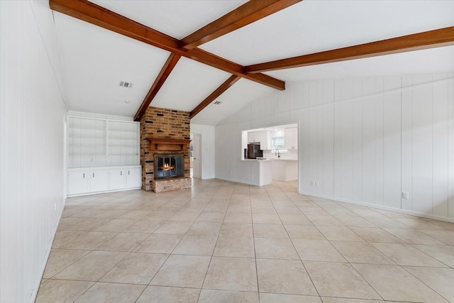 unfurnished living room featuring a brick fireplace, vaulted ceiling with beams, and light tile patterned floors