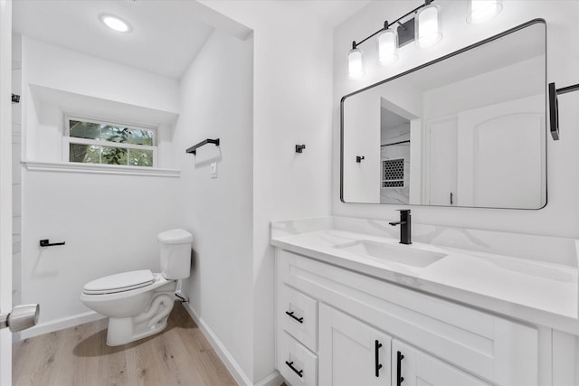 bathroom with vanity, toilet, and hardwood / wood-style floors