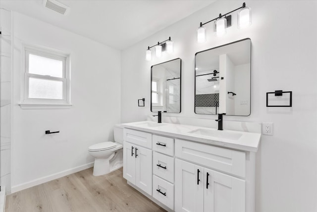 bathroom featuring vanity, hardwood / wood-style flooring, toilet, and a shower