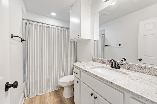 bathroom with hardwood / wood-style floors, toilet, and vanity