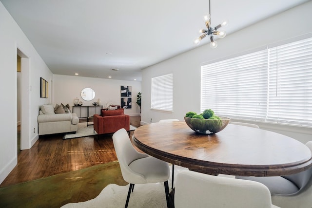 dining area with dark wood finished floors, baseboards, and an inviting chandelier