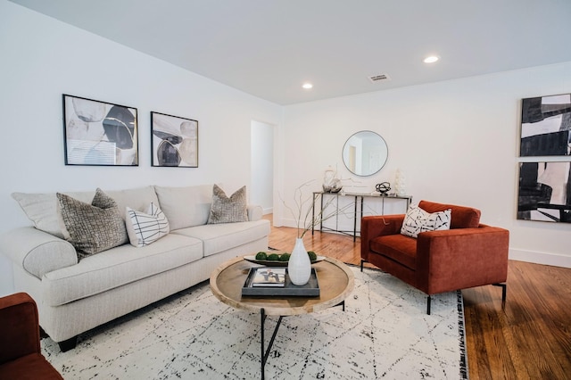 living area featuring baseboards, visible vents, wood finished floors, and recessed lighting