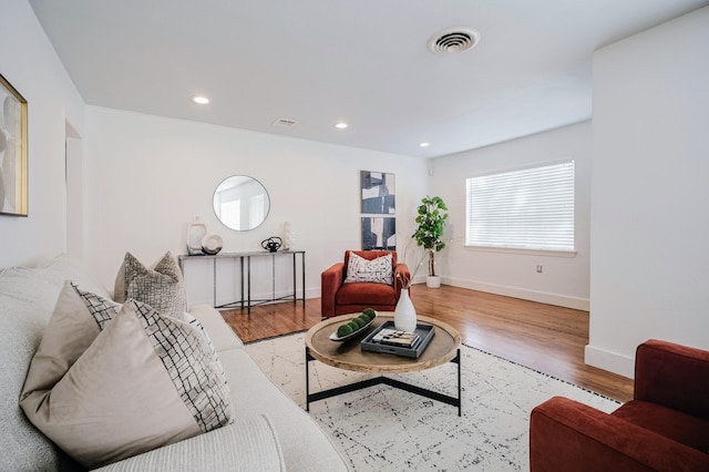 living area with baseboards, light wood-style flooring, visible vents, and recessed lighting