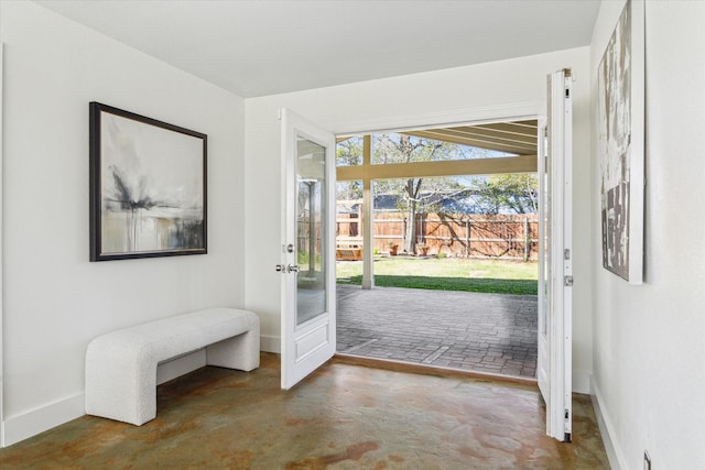 doorway to outside featuring concrete flooring and baseboards