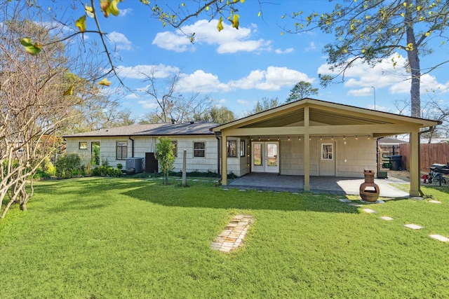 rear view of property with a patio, a carport, and a lawn