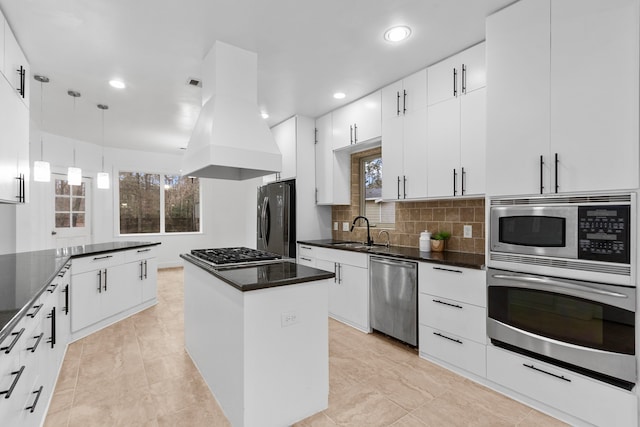 kitchen with pendant lighting, sink, island exhaust hood, a center island, and stainless steel appliances