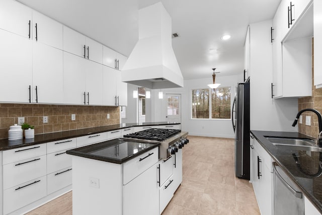 kitchen with white cabinetry, island range hood, stainless steel appliances, and sink