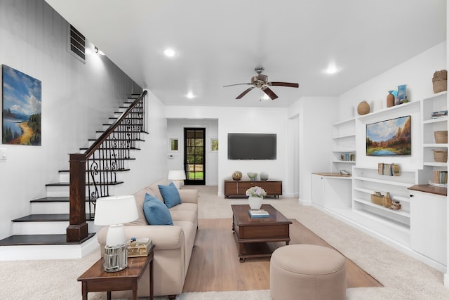 living room with ceiling fan and light colored carpet