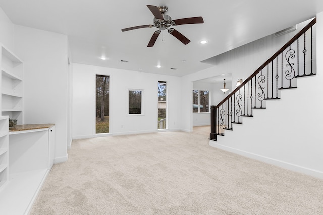 unfurnished living room with ceiling fan and light carpet