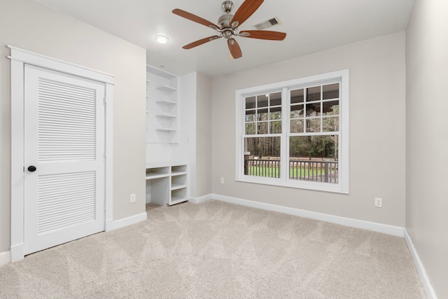 unfurnished bedroom with light colored carpet, ceiling fan, and a closet