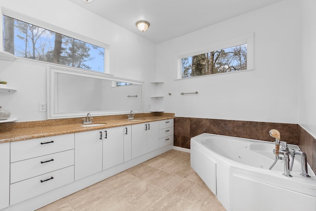 bathroom with tile patterned flooring, vanity, plenty of natural light, and a washtub