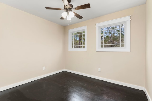 spare room featuring dark wood-type flooring and ceiling fan