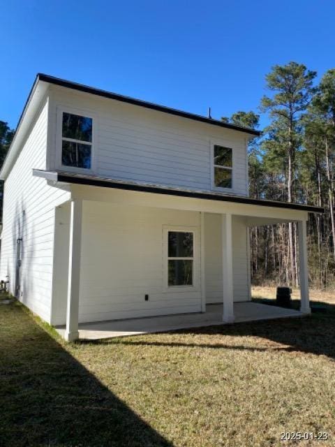 back of property featuring a patio and a lawn