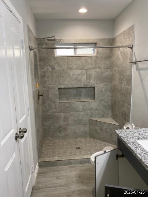 bathroom featuring vanity and tiled shower