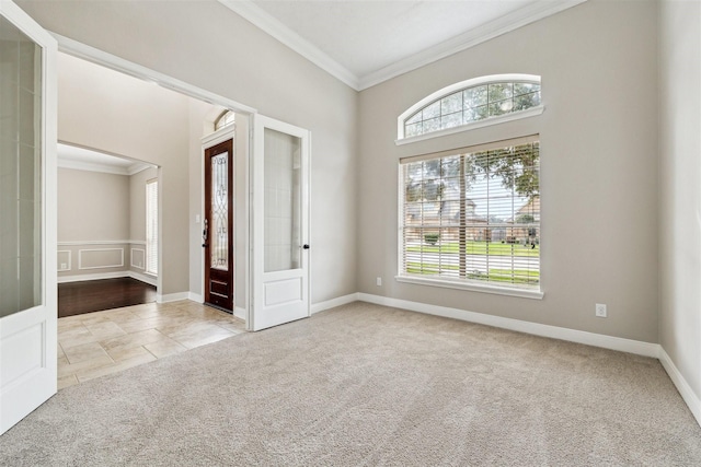 unfurnished room featuring crown molding, light colored carpet, and a wealth of natural light