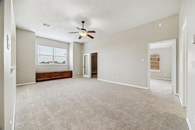 interior space featuring light carpet, ceiling fan, and a textured ceiling