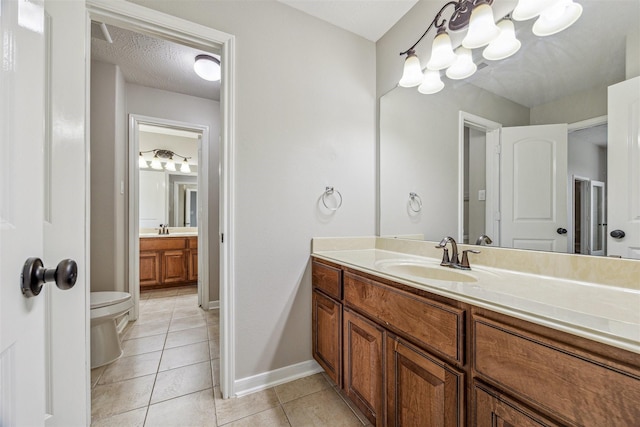 bathroom featuring vanity, tile patterned floors, a textured ceiling, and toilet