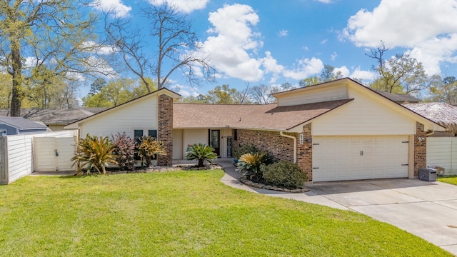 view of front of property with driveway, fence, an attached garage, a front yard, and brick siding