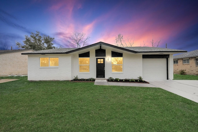 view of front of home featuring a garage and a yard