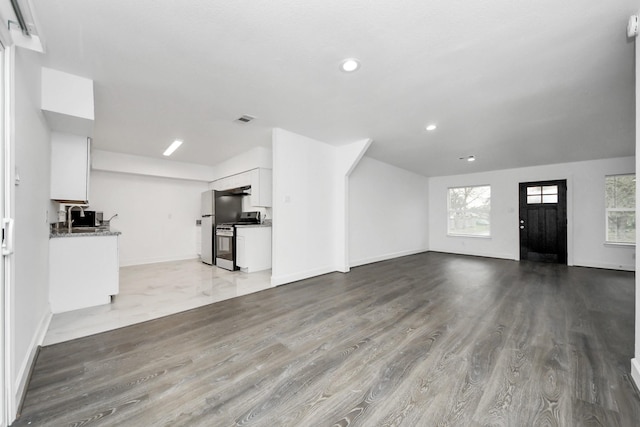 unfurnished living room with sink and light hardwood / wood-style floors