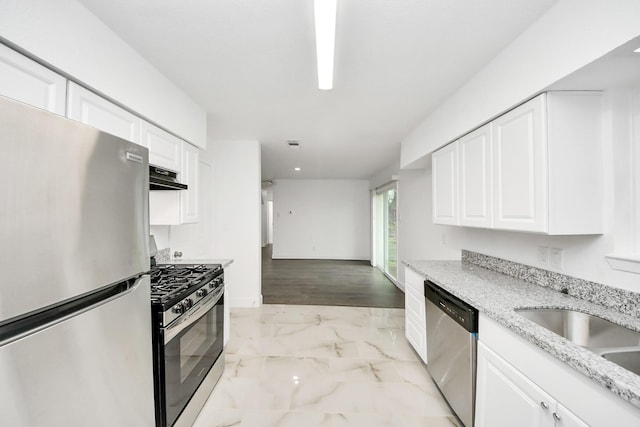 kitchen featuring light stone countertops, white cabinetry, appliances with stainless steel finishes, and sink