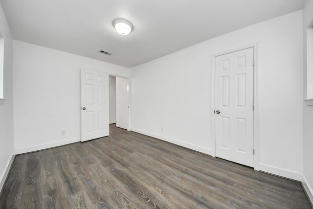 unfurnished bedroom with dark wood-type flooring