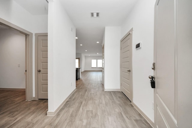 corridor with light hardwood / wood-style floors