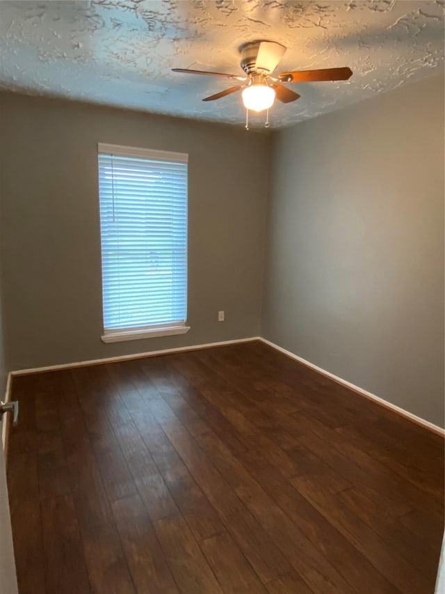 unfurnished room featuring ceiling fan, dark hardwood / wood-style floors, and a textured ceiling