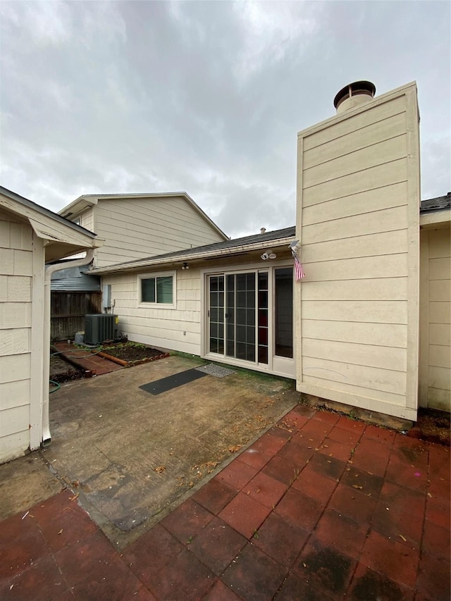 rear view of house featuring central AC unit and a patio area