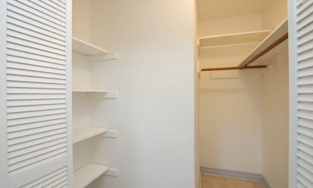 walk in closet with light tile patterned flooring