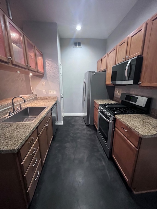 kitchen featuring light stone countertops, baseboards, visible vents, a sink, and stainless steel appliances