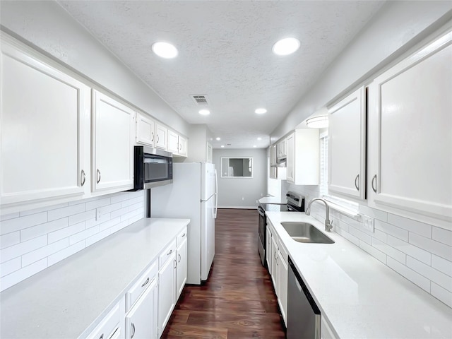 kitchen with stainless steel appliances, dark hardwood / wood-style floors, sink, and white cabinets