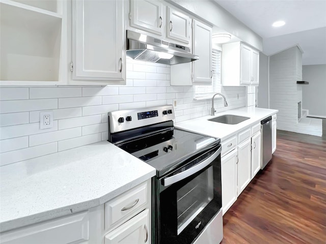 kitchen featuring stainless steel appliances, white cabinetry, light stone countertops, and sink