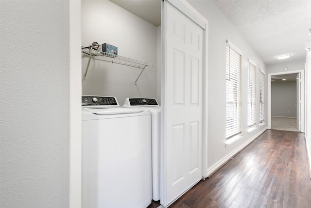 laundry room featuring dark wood-type flooring, washer and clothes dryer, and a textured ceiling