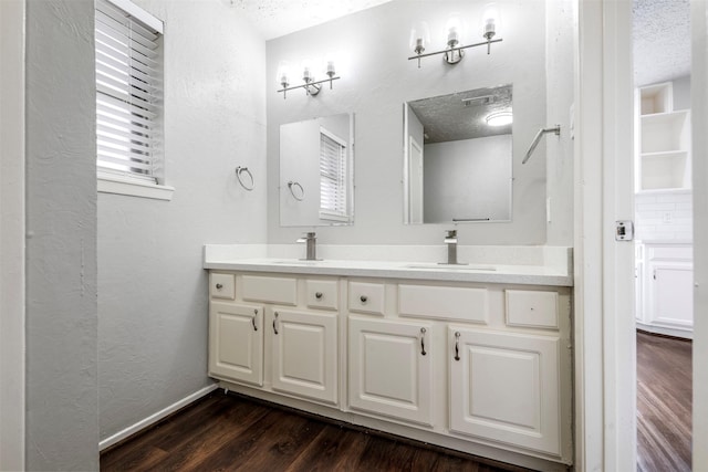 bathroom featuring vanity, hardwood / wood-style flooring, and a textured ceiling