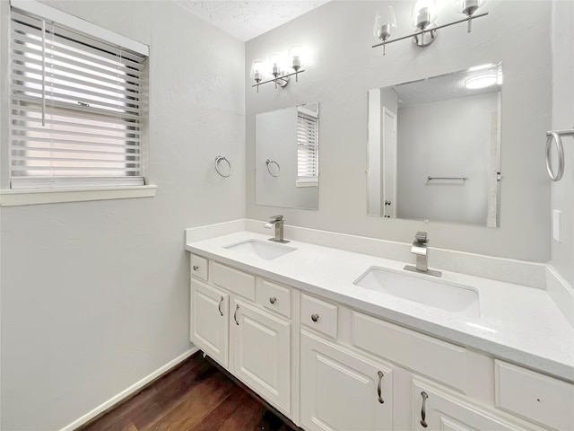 bathroom featuring vanity, plenty of natural light, hardwood / wood-style floors, and a textured ceiling