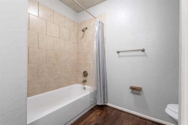 bathroom featuring shower / bathtub combination with curtain, hardwood / wood-style floors, a textured ceiling, and toilet