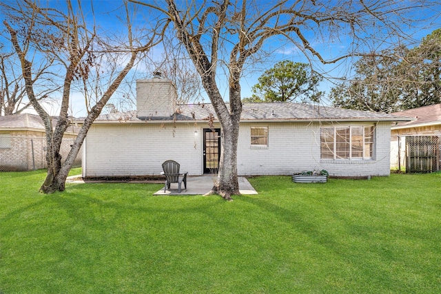 rear view of property featuring a yard and a patio area