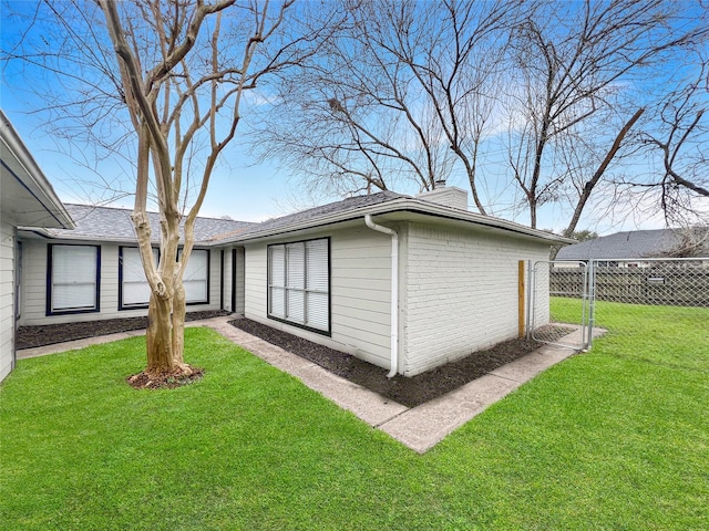 view of side of home with a yard