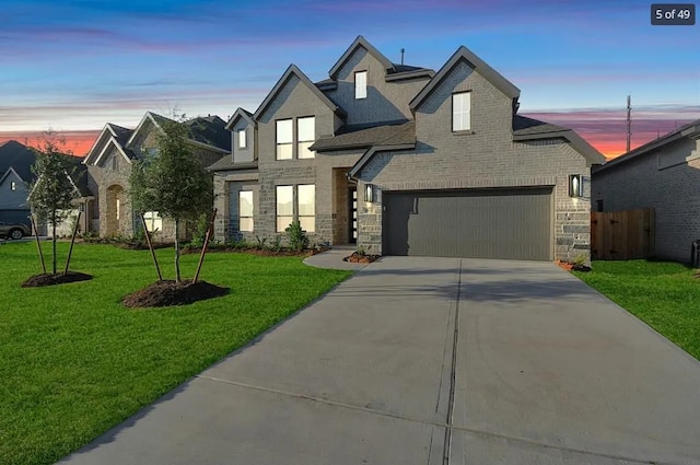 view of front of property with a garage and a yard