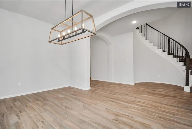 unfurnished dining area featuring a chandelier and light hardwood / wood-style flooring