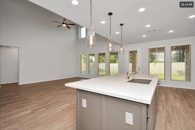 kitchen with pendant lighting, sink, a center island with sink, and plenty of natural light