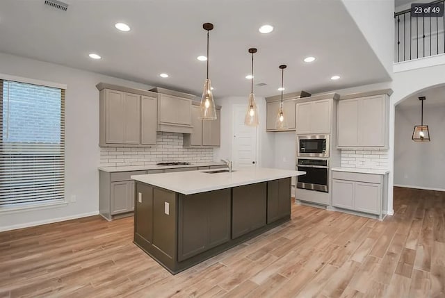 kitchen with pendant lighting, stainless steel appliances, sink, and gray cabinetry