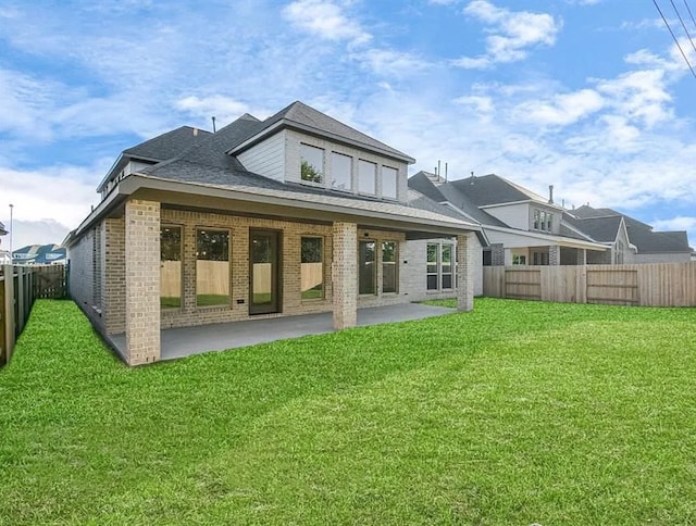 rear view of property featuring a yard and a patio area