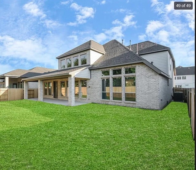 rear view of house with a patio area and a lawn