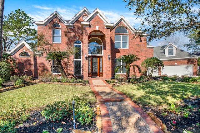 traditional-style home featuring a garage, brick siding, and a front lawn