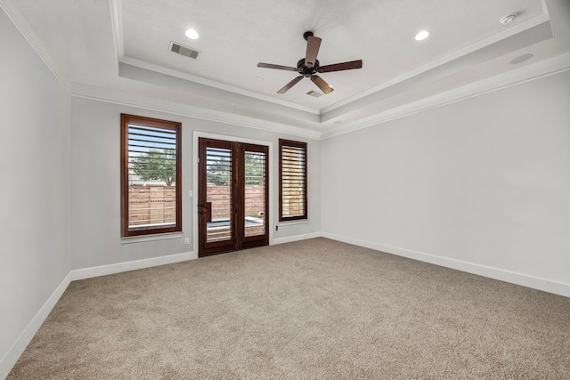 carpeted empty room with french doors, ornamental molding, ceiling fan, and a tray ceiling