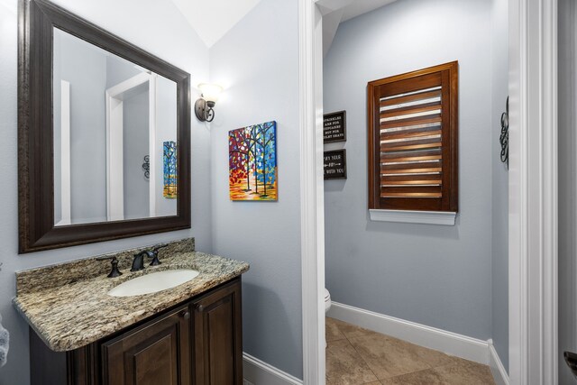 bathroom with vanity, toilet, and tile patterned flooring