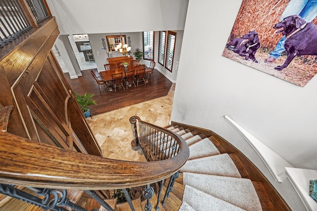 stairs with a chandelier and hardwood / wood-style floors