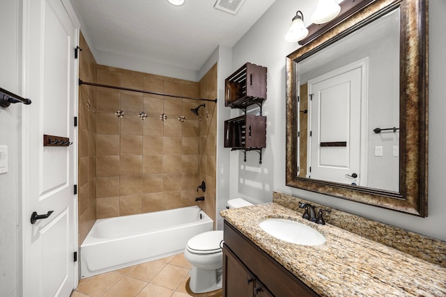 full bathroom featuring tile patterned flooring, vanity, tiled shower / bath combo, and toilet